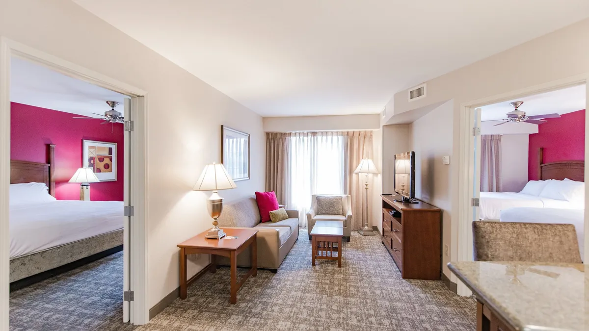The image showcases a welcoming living space with a plush sofa, warm lighting from a nearby lamp, a dining table perfect for shared meals, and a television set up for cozy entertainment. The arrangement invites relaxation, conversation, and family time, encapsulating the comfort of home within a stylish condo setting.